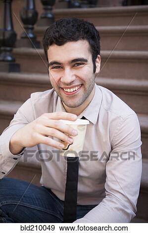 Hispanic businessman drinking coffee on front steps View Large Photo Image Stock Photo - Hispanic businessman drinking coffee on front steps. Fotosearch