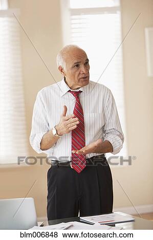 Hispanic businessman talking in office View Large Photo Image Stock Photo - Hispanic businessman talking in office. Fotosearch