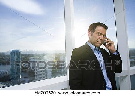Stock Image - Hispanic businessman talking on cell phone. Fotosearch