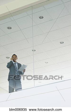 Stock Photography - Hispanic businessman talking on cell phone. Fotosearch