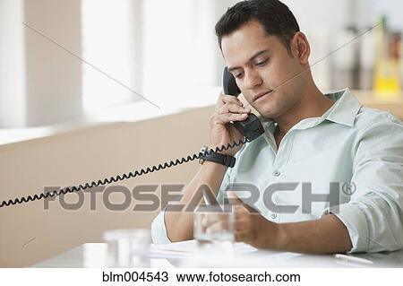 Stock Image - Hispanic businessman talking on telephone. Fotosearch