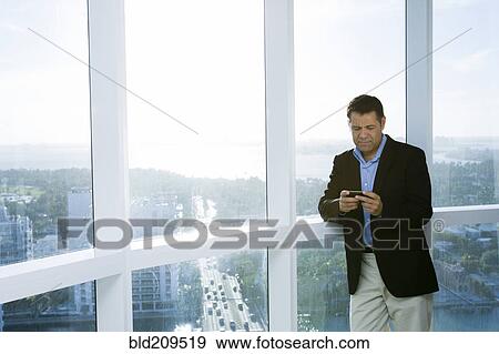 Stock Photo - Hispanic businessman using cell phone. Fotosearch