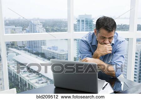 Stock Image - Hispanic businessman working in office. Fotosearch