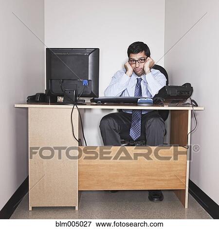 Stock Photo - Hispanic businessman working in small office. Fotosearch