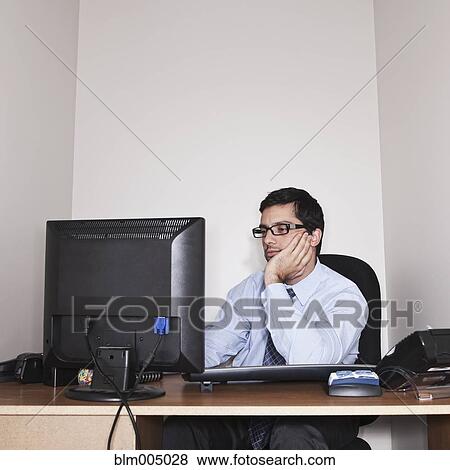 Stock Photo - Hispanic businessman working in small office. Fotosearch