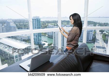 Stock Photo - Hispanic businesswoman using digital tablet. Fotosearch