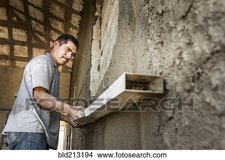Picture - Hispanic construction worker at construction site. Fotosearch