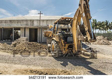Stock Image - Hispanic construction worker on bulldozer at construction site. Fotosearch