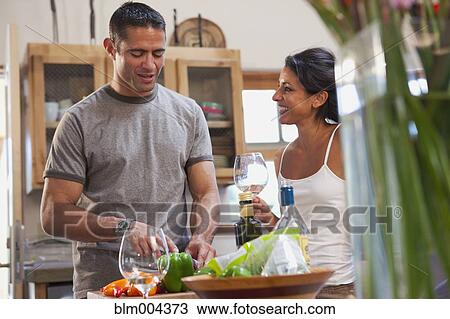 Stock Image - Hispanic couple preparing dinner. Fotosearch