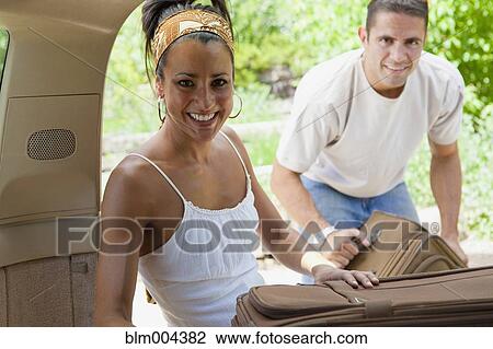 Hispanic couple putting suitcases in car View Large Photo Image Stock Image - Hispanic couple putting suitcases in car. Fotosearch