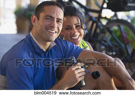 Stock Photo - Hispanic couple resting after bike ride. Fotosearch