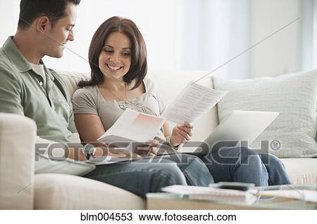Stock Image - Hispanic couple reviewing monthly bills. Fotosearch