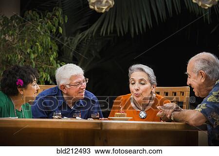 Stock Image - Hispanic couples celebrating birthday outdoors. Fotosearch