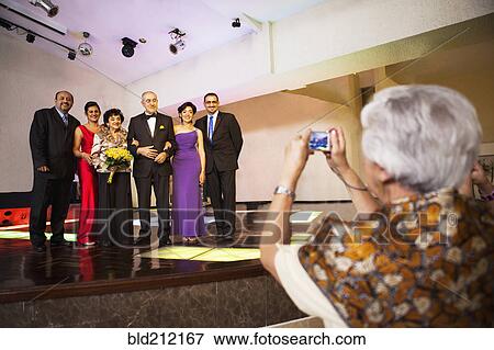 Hispanic family taking pictures at wedding reception View Large Photo Image Stock Photo - Hispanic family taking pictures at wedding reception. Fotosearch