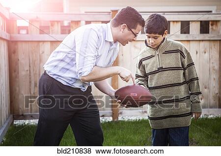 Hispanic father teaching son to play football View Large Photo Image Stock Photo - Hispanic father teaching son to play football. Fotosearch