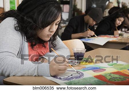 Stock Photography - Hispanic girl painting in art class. Fotosearch