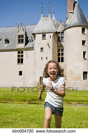 Stock Image - Hispanic girl running with castle in background. Fotosearch