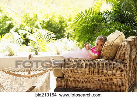 Hispanic girl sitting in armchair outdoors View Large Photo Image Picture - Hispanic girl sitting in armchair outdoors. Fotosearch