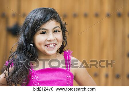Stock Image - Hispanic girl smiling outdoors. Fotosearch