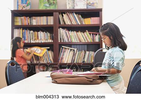 Stock Image - Hispanic girls in library. Fotosearch
