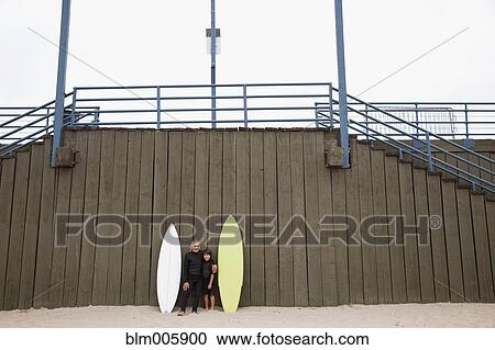 Hispanic grandfather and grandson in wet suits with surfboards View Large Photo Image Stock Image - Hispanic grandfather and grandson in wet suits with surfboards. Fotosearch