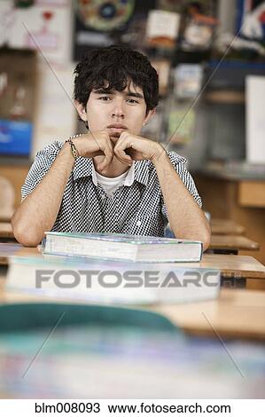 Hispanic high school student sitting at desk in classroom View Large Photo Image Stock Image - Hispanic high school student sitting at desk in classroom. Fotosearch
