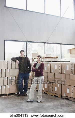 Hispanic man and woman in warehouse View Large Photo Image Stock Image - Hispanic man and woman in warehouse. Fotosearch