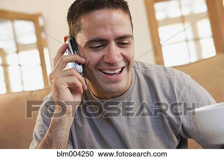 Hispanic man drinking coffee and talking on cell phone View Large Photo Image Stock Image - Hispanic man drinking coffee and talking on cell phone. Fotosearch