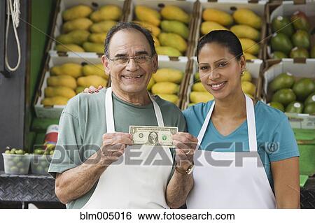 Hispanic man holding first dollar bill View Large Photo Image Stock Photograph - Hispanic man holding first dollar bill. Fotosearch