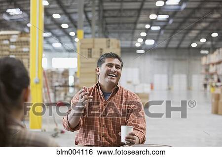 Hispanic man laughing and drinking coffee in warehouse View Large Photo Image Stock Photograph - Hispanic man laughing and drinking coffee in warehouse. Fotosearch