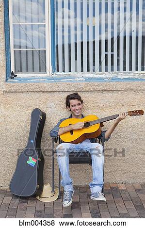 Hispanic man playing guitar View Large Photo Image Stock Photo - Hispanic man playing guitar. Fotosearch