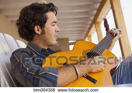 Stock Photograph - Hispanic man playing guitar. Fotosearch