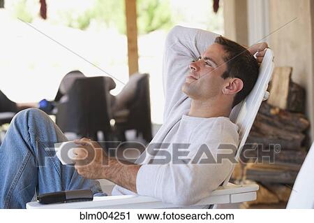 Hispanic man relaxing in deck chair with coffee View Large Photo Image Stock Image - Hispanic man relaxing in deck chair with coffee. Fotosearch