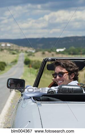 Hispanic man riding in convertible View Large Photo Image Stock Photo - Hispanic man riding in convertible. Fotosearch
