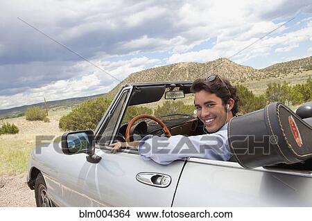 Hispanic man riding in convertible with guitar case View Large Photo Image Picture - Hispanic man riding in convertible with guitar case. Fotosearch