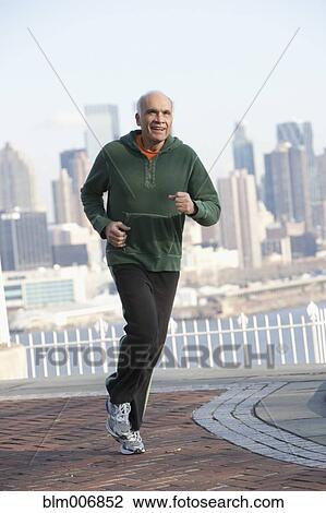 Stock Image - Hispanic man running in urban setting. Fotosearch