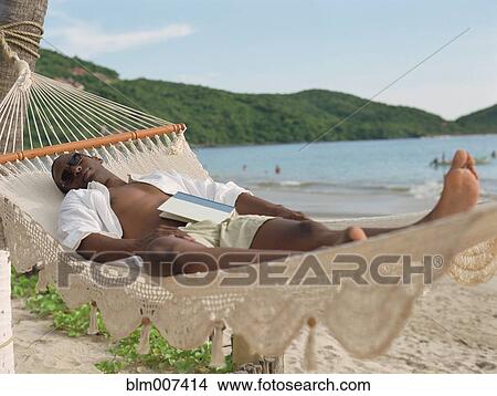 Hispanic man sleeping in hammock at beach View Large Photo Image Picture - Hispanic man sleeping in hammock at beach. Fotosearch