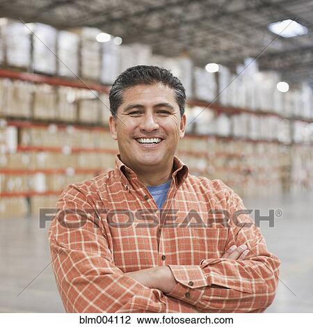 Hispanic man smiling in warehouse View Large Photo Image Stock Image - Hispanic man smiling in warehouse. Fotosearch
