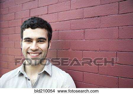 Picture - Hispanic man smiling outdoors. Fotosearch