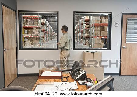 Hispanic man standing in warehouse office View Large Photo Image Stock Photo - Hispanic man standing in warehouse office. Fotosearch