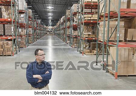 Hispanic man standing with arms crossed in warehouse View Large Photo Image Stock Image - Hispanic man standing with arms crossed in warehouse. Fotosearch