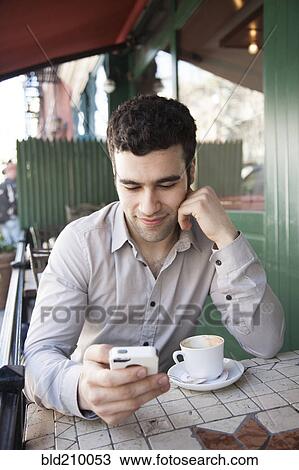 Hispanic man using cell phone at sidewalk cafe View Large Photo Image Stock Image - Hispanic man using cell phone at sidewalk cafe. Fotosearch