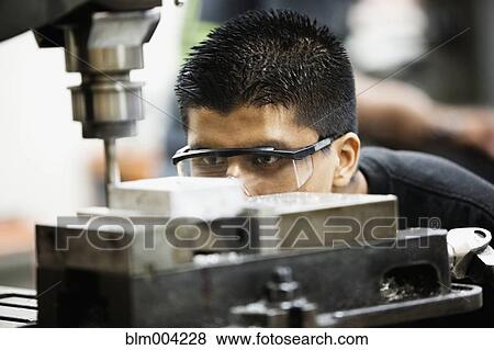 Hispanic man using machine in machine shop View Large Photo Image Stock Photo - Hispanic man using machine in machine shop. Fotosearch