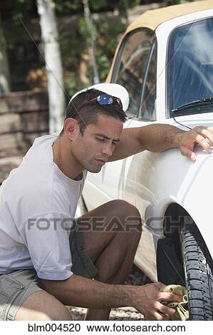 Stock Image - Hispanic man washing his car. Fotosearch