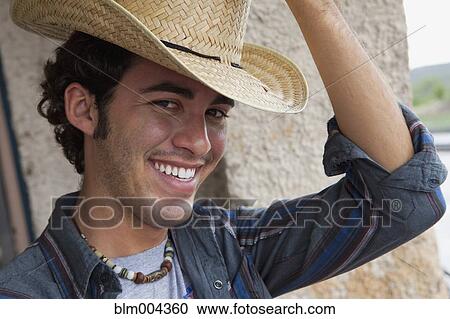 Stock Image - Hispanic man wearing cowboy hat. Fotosearch