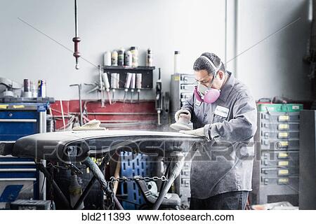 Stock Image - Hispanic mechanic working in auto shop. Fotosearch