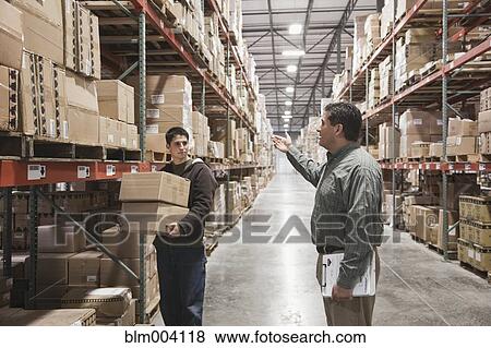 Stock Photo - Hispanic men working in warehouse. Fotosearch