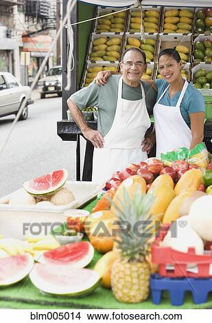 Picture - Hispanic people working at fruit stall. Fotosearch