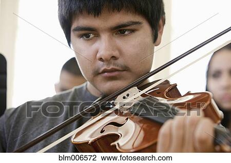 Stock Image - Hispanic student practicing on violin. Fotosearch