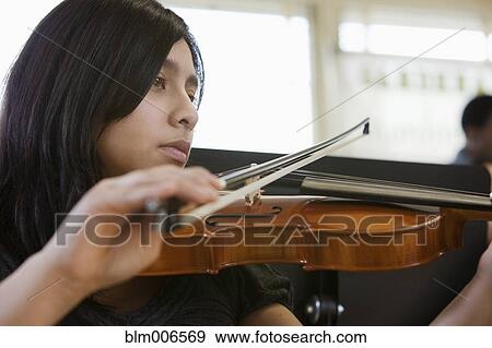 Stock Photo - Hispanic student practicing on violin. Fotosearch